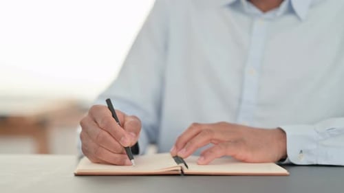 African Man Hands Writing on Notebook Close Up