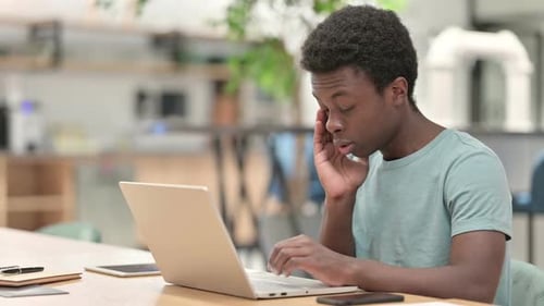 Young Adult Working on Laptop Gets Headache