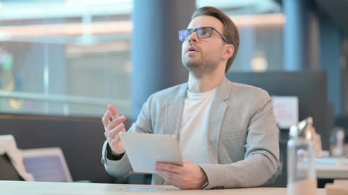 Man Using Tablet Expresses Frustration in Office