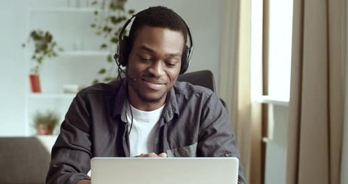 Man Wearing Headset Talking on Laptop