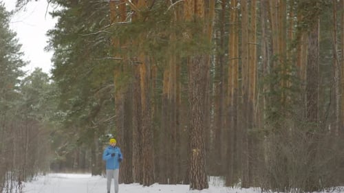 Athletic Man Running in Forest in Winter