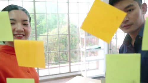 Team Brainstorming Using Sticky Notes in Modern Office