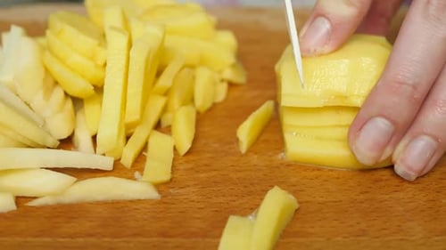 Corte de batatas com faca na mesa em processo de cozimento