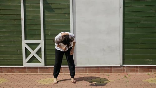 Woman is Practicing Hip Hop and Dancehall Movements Outdoors at Summertime