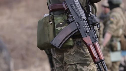 Am Checkpoint einer Militärbasis bewacht ein bewaffneter Soldat mit Maschinenpistole ein Objekt