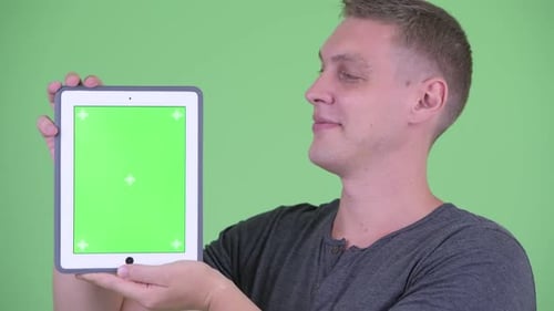 Young Adult Holding Tablet With Green Screen