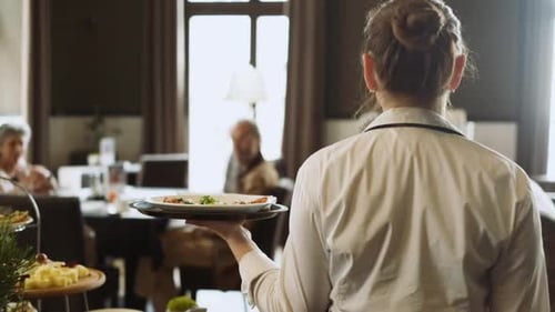 Waitress Serving Food in Elegant Urban Restaurant
