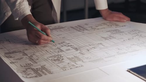 Close Up of Engineer's Hands Making Notes on Control Electronics Scheme