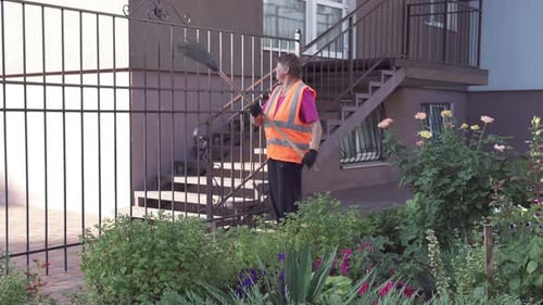 Un concierge de rue ramasse les ordures. La propreté et l'ordre dans la cour dépendent du concierge.
