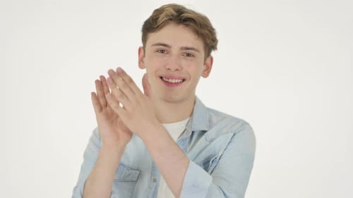 Junger Mann klatscht applaudierend auf weißem Hintergrund