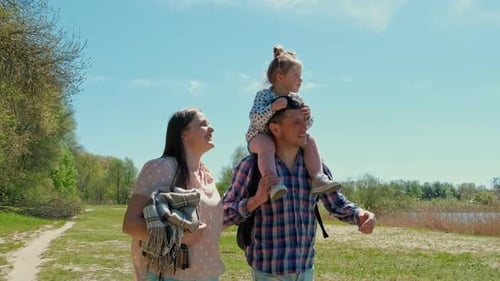Happy Family Resting in Nature Near the Forest