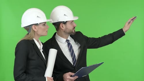 Engineers Studying Construction Documents Against Chroma Key