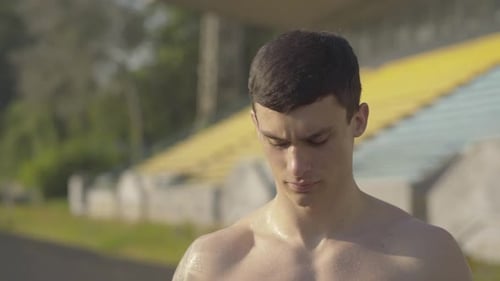 Sweaty Athlete Drying Face with Towel Outside