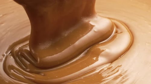 Pouring melted caramel, closeup food shot.