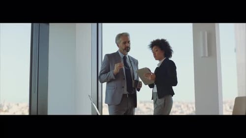 Business Colleagues Discussing Data on Tablet in Modern Office