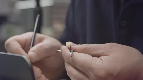 Dental Technician Working on Tooth with Small Brush