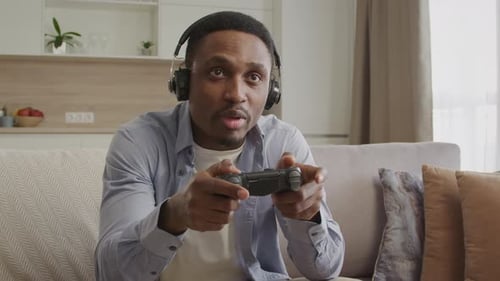 Excited Man Playing Video Game At Home