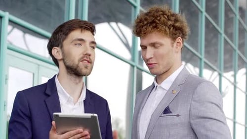 Businessmen Discussing Digital Strategy on Tablet Outdoors