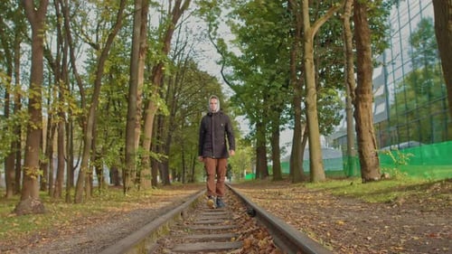 Ein junger Mann bewegt sich selbstbewusst zur Kamera im Park auf der Strecke