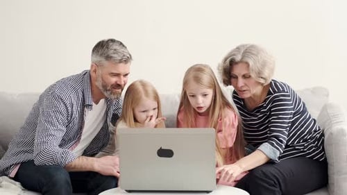 Family Gathers Around Laptop in Home Setting