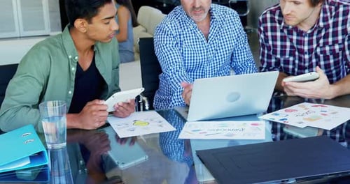 Business Colleagues Collaborating Around Table with Laptop