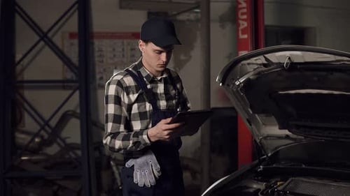 Mechanic Inspecting Car Using Tablet in Garage