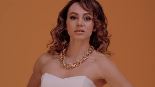 Glamorous Woman with Gold Necklace in Studio Setting