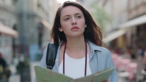 Woman Walking and Reading Map in City