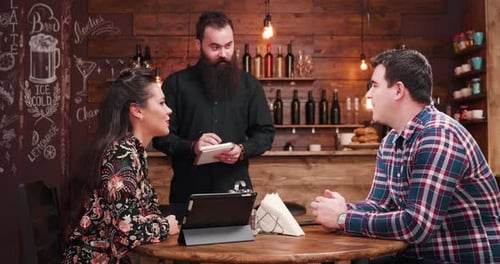 Couple Ordering Food in Restaurant from Friendly Server