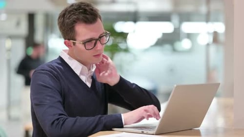 Adult Typing on Laptop in Office Stretches Neck