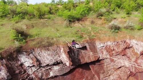 Woman Tightrope Walking Across Rocky Ravine Outdoors
