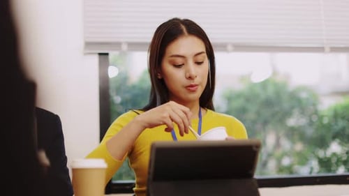 Woman Eating Noodles at Desk in Office