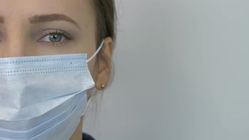 Portrait of young woman in protective medical face mask. Pandemic protection of coronavirus