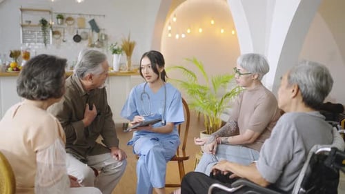 Senior people sit in a circle in a nursing home listen nurse during a group elderly therapy session