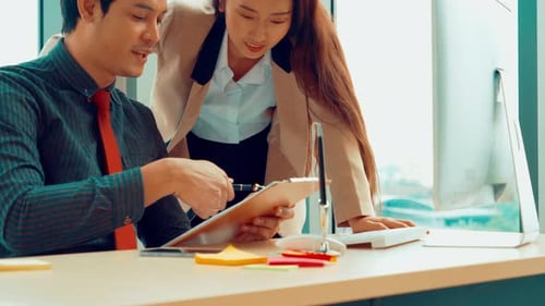 Two Business People Talk Project Strategy at Office