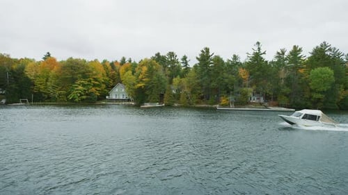 Motorboat Driving Through Lake With Autumn Trees