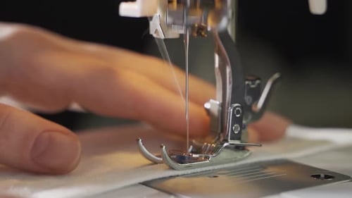 Sewing Machine Needle Stitching Fabric in Close Up