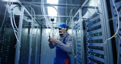 Technician Cutting Wires at a Data Center