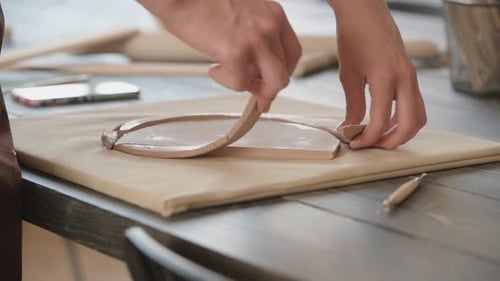 Close Up of Skilled Craftswoman Removing Part of Clay While Making Ceramic Product in Pottery