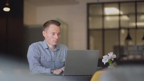 Jovem freelancer trabalhando no computador em casa