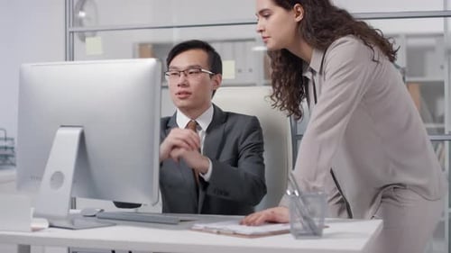 Workers Collaborating on Computer in Modern Office
