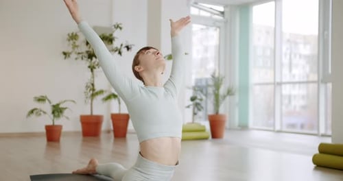 Une belle femme pratique des exercices de spagat dans le studio lumineux Anjaneyasana