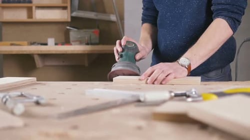 Worker Grinds the Wood of Angular Grinding Machine