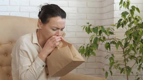 Une femme malade respire dans le sac.