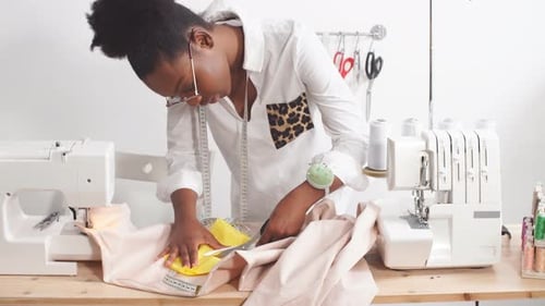 Woman Cuts Fabric at Bright Sewing Station