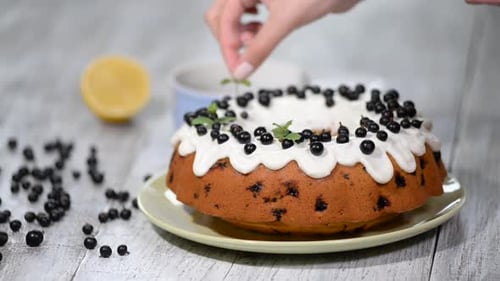 Dekorieren Sie einen hausgemachten Zitronenkuchen mit Blaubeeren auf einem rustikalen Holzhinter