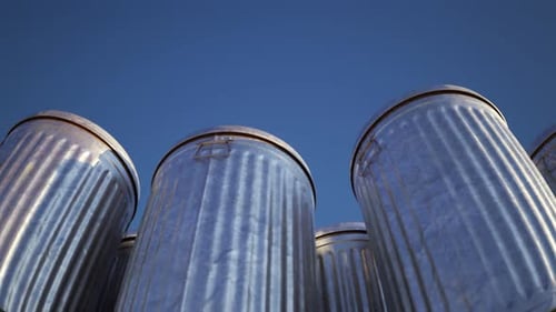 Steel trash bins stacked together in an endless loop lit by the sunlight. 4KHD