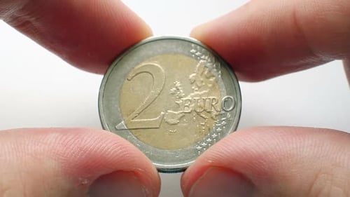 Fingers Holding Two Euro Coin
