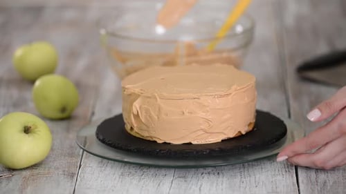 Person Frosting Cake with Smooth, Brown Frosting