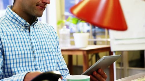 Adult Using Digital Tablet at Desk in Daytime